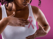Lifestyle and Breast Cancer: How Are They Related? Michelle Insiadoo, RD Shares Insights Black women waering a white shirt with a pink breast cancer ribbon