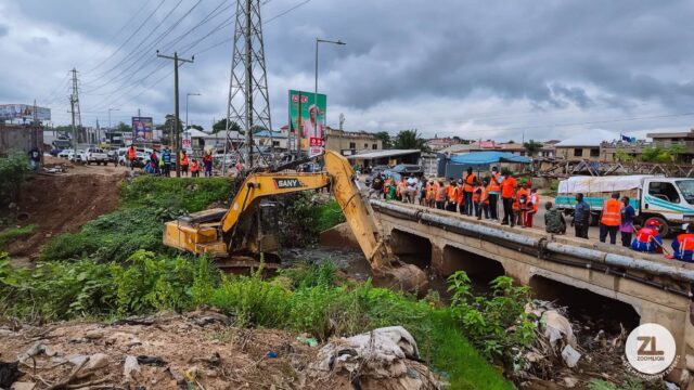 Zoomlion Deploys Heavy Logistics for National Clea-Up Days. An excavator clearing thick silt from a large, choked storm drain to prevent flooding.